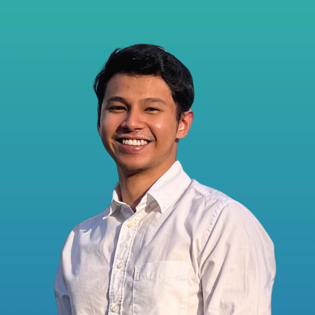 Izran Julainie, our therapist is wearing white and smiling in front of the camera